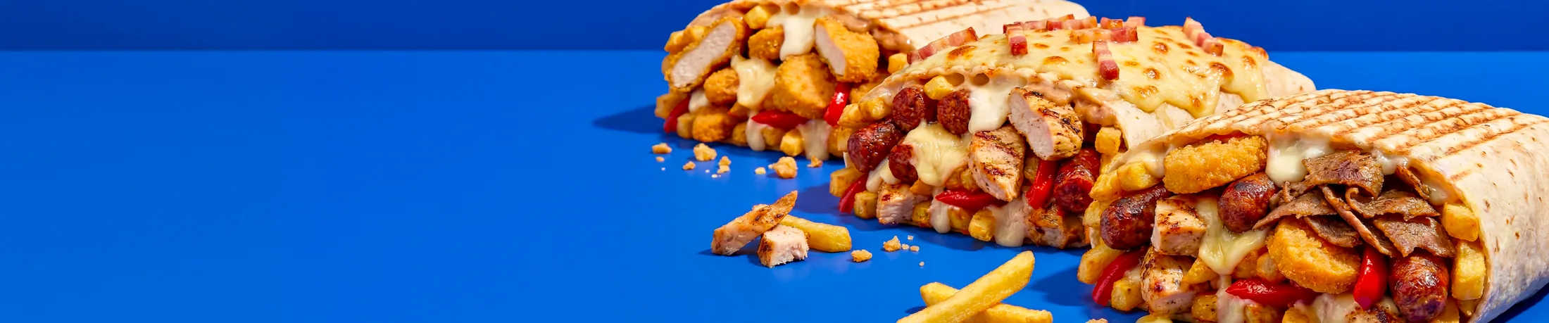 Un French Tacos coupé en deux, la garniture et le fromage fondu visibles